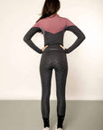 Model wearing charcoal grey riding leggings with pink and grey base layer top.