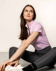 Model sitting down wearing- Grey riding leggings and lilac base layer.