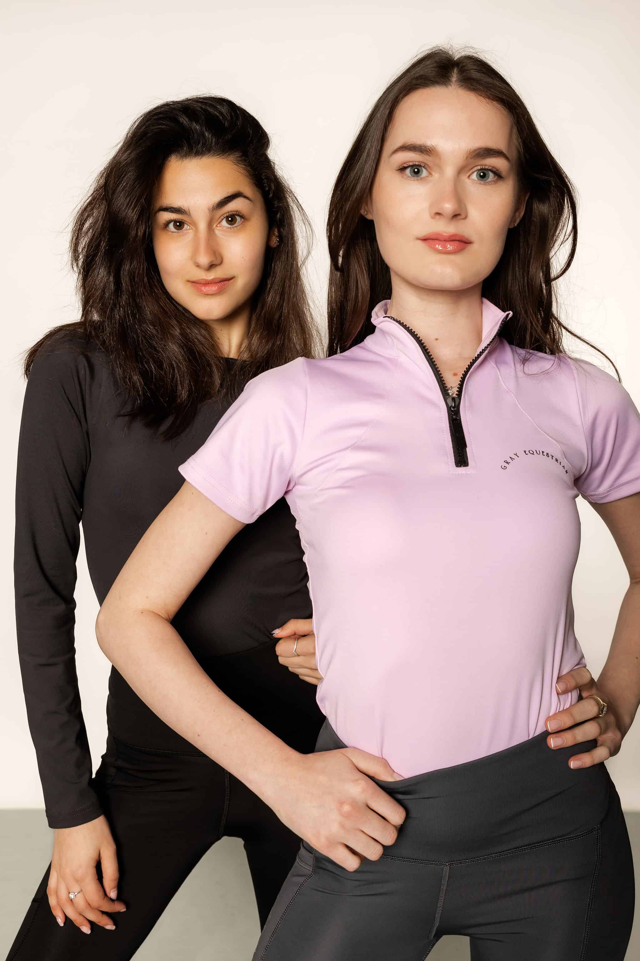 Brunette model wearing lilac short sleeved equestrian base layer with black 1/4 zip