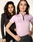 Brunette model wearing lilac short sleeved equestrian base layer with black 1/4 zip