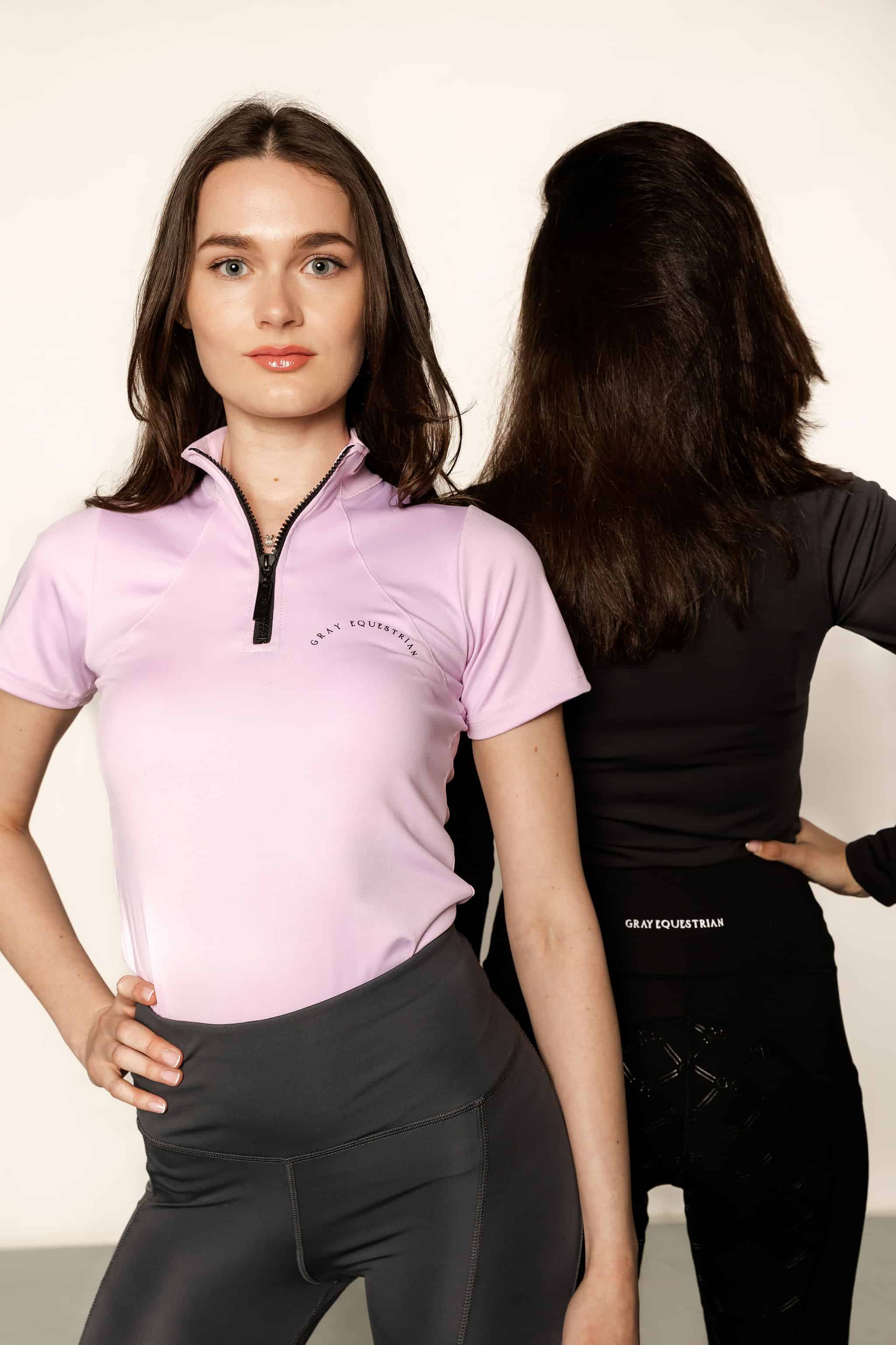 Two models back to back with lilac base layer and grey leggings on and black riding leggings.