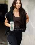 A brunette model wearing our brown scoop neck equestrian vest in a tight-fitting breathable fabric.