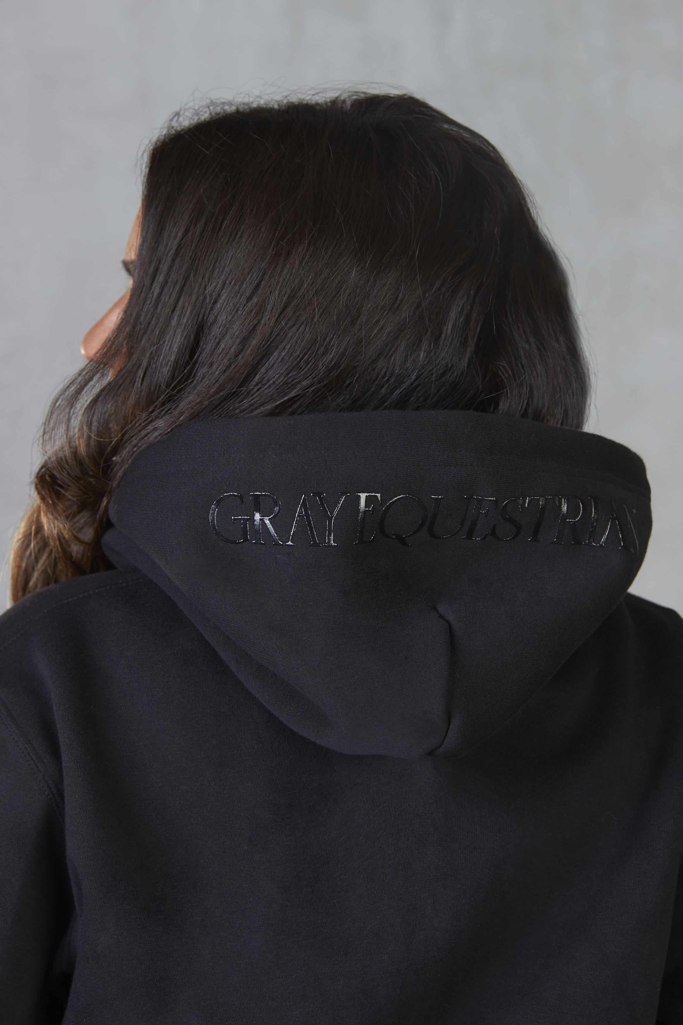 A view of the back of the hoodie, with subtle Grey Equestrian branding on the hood.