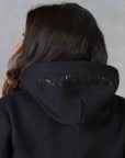A view of the back of the hoodie, with subtle Grey Equestrian branding on the hood.
