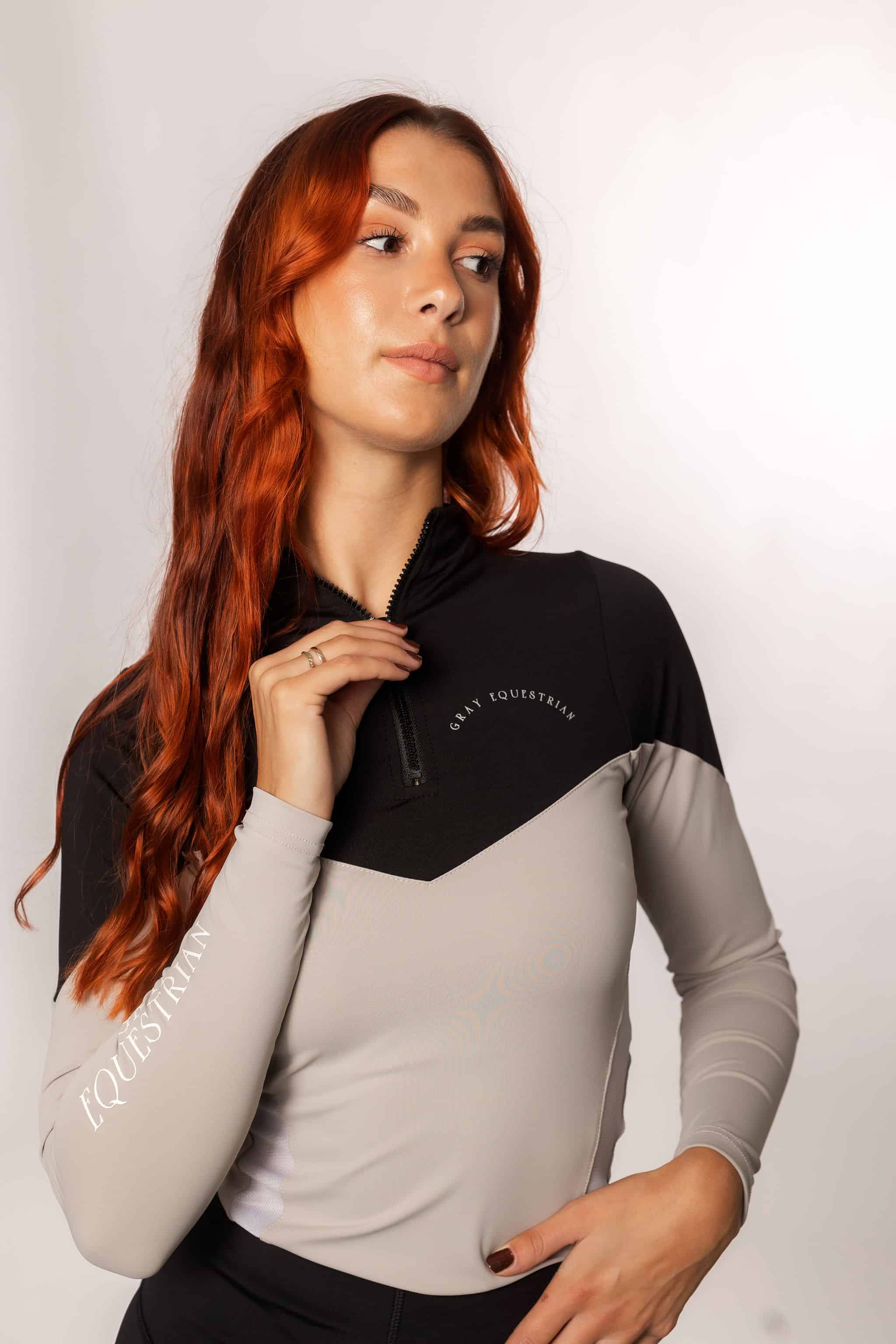 Red haired model wearing our long-sleeved black and grey two toned base layer.