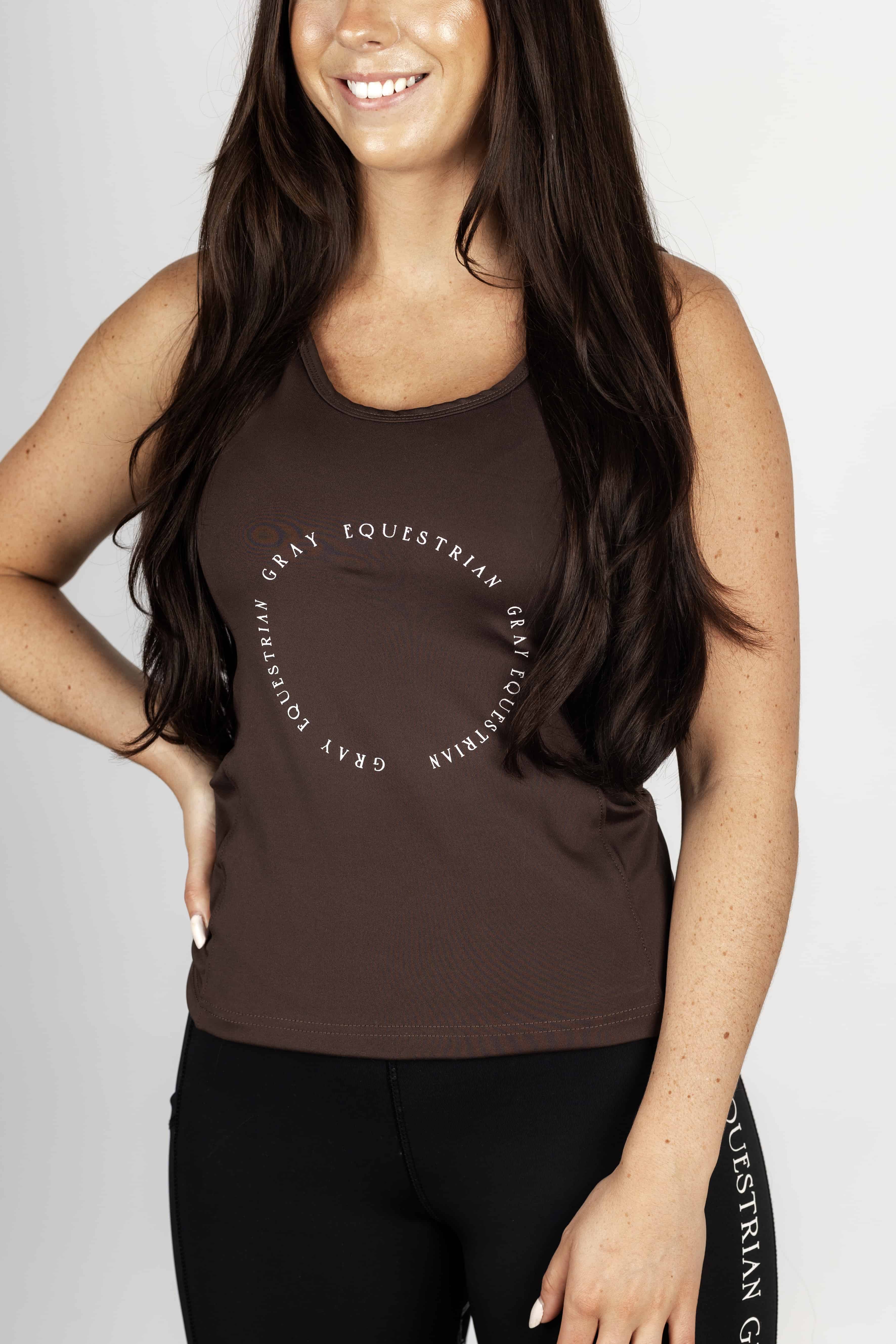 A brunette model wearing our brown scoop neck equestrian vest in a tight-fitting breathable fabric.