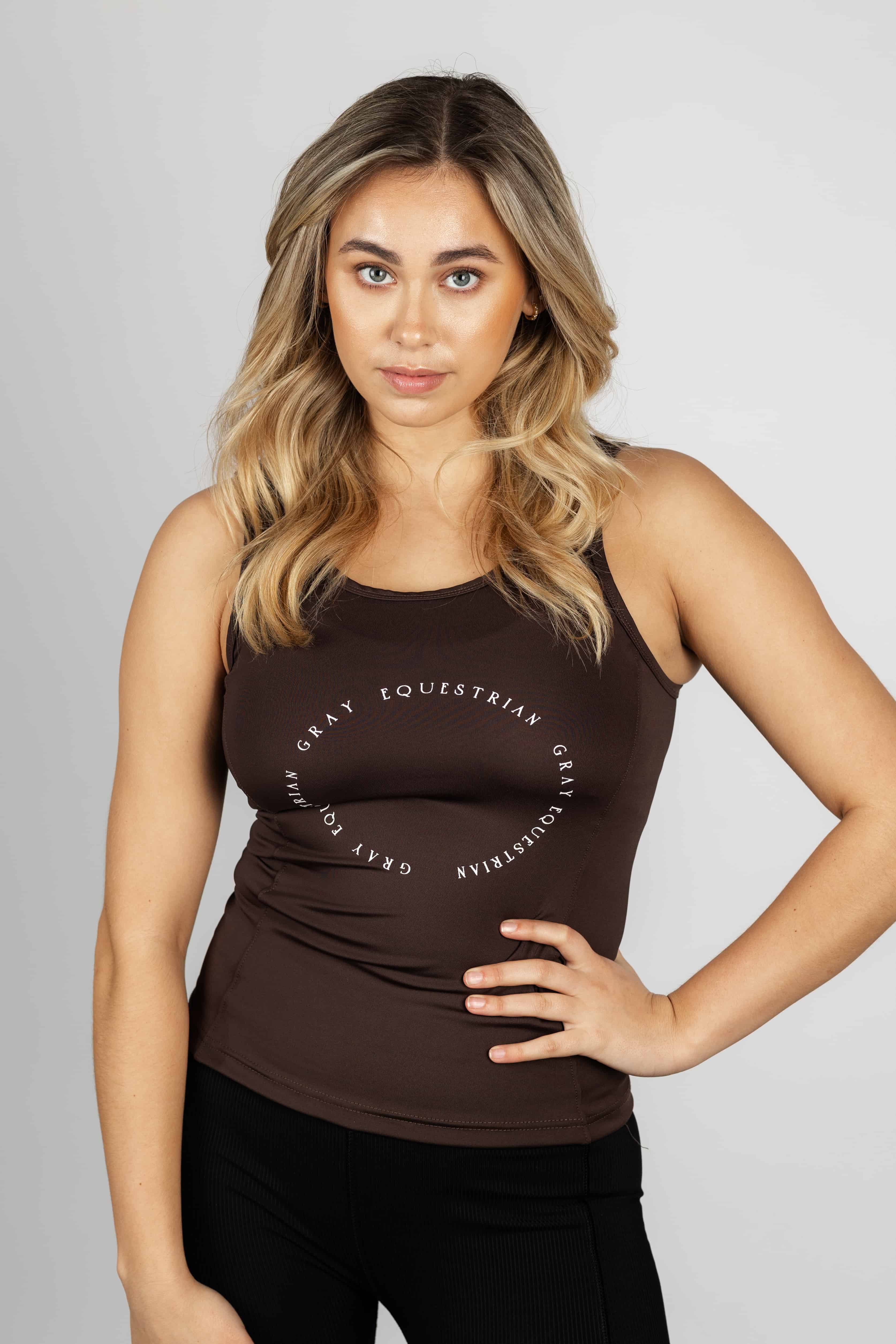 A blonde model wearing our brown scoop neck equestrian vest in a tight-fitting breathable fabric.