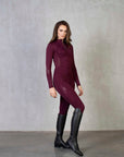 Brunette model wearing our burgundy equestrian leggings and matching long sleeved base layer.