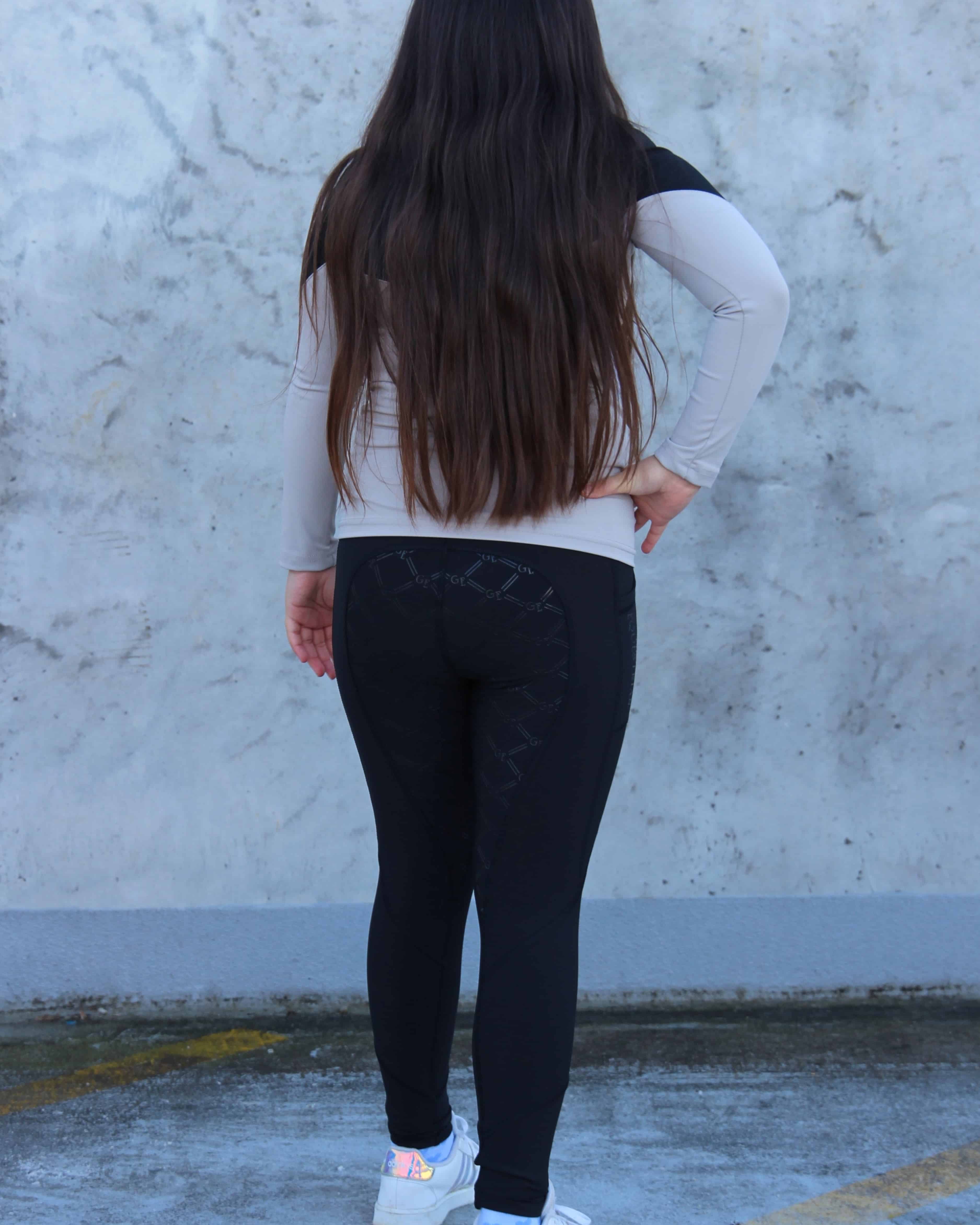 A child model wearing our black fleece lined riding leggings.