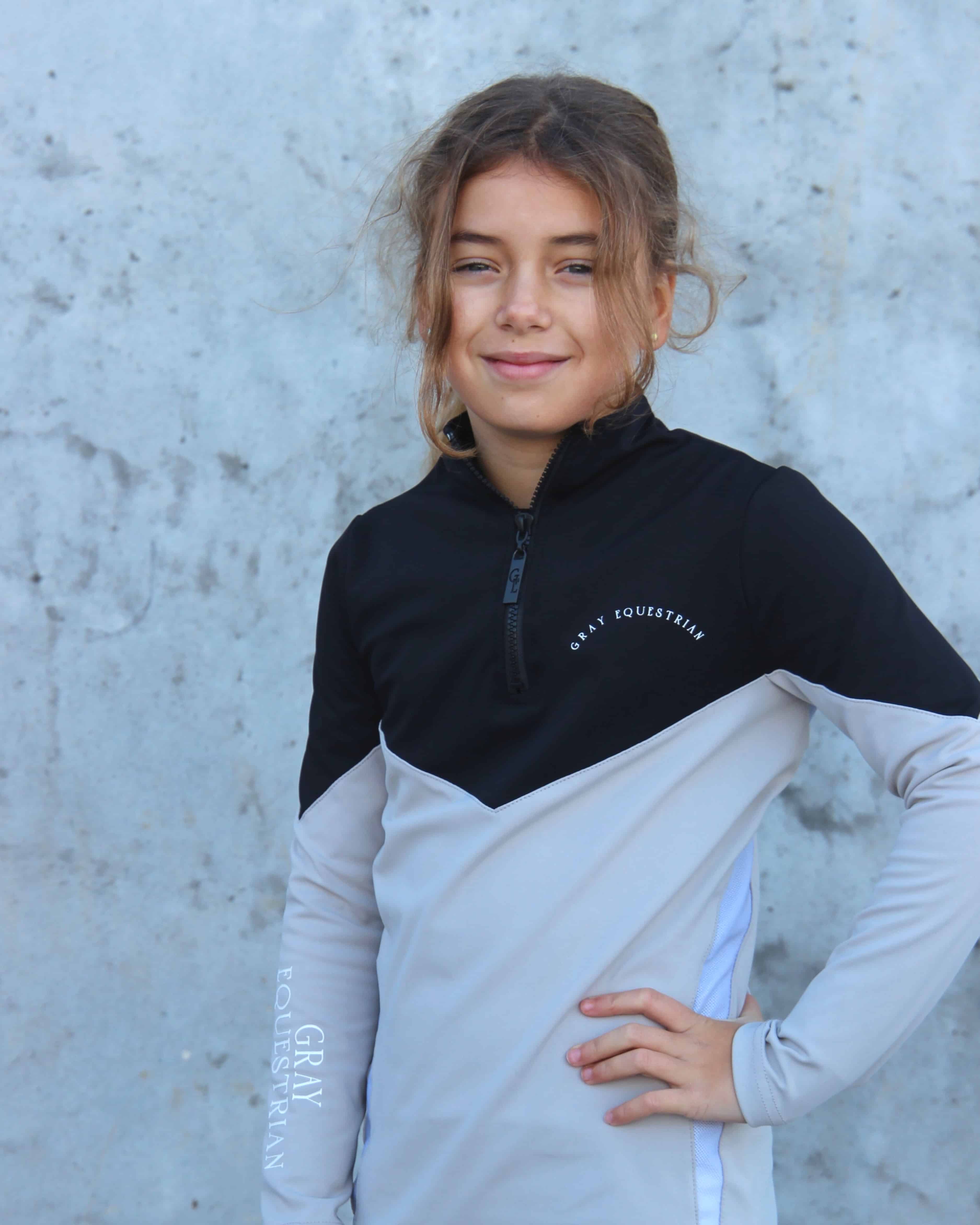 Our child model wearing our black and grey two toned base layer.