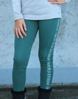A child model wearing our green renew riding leggings.
