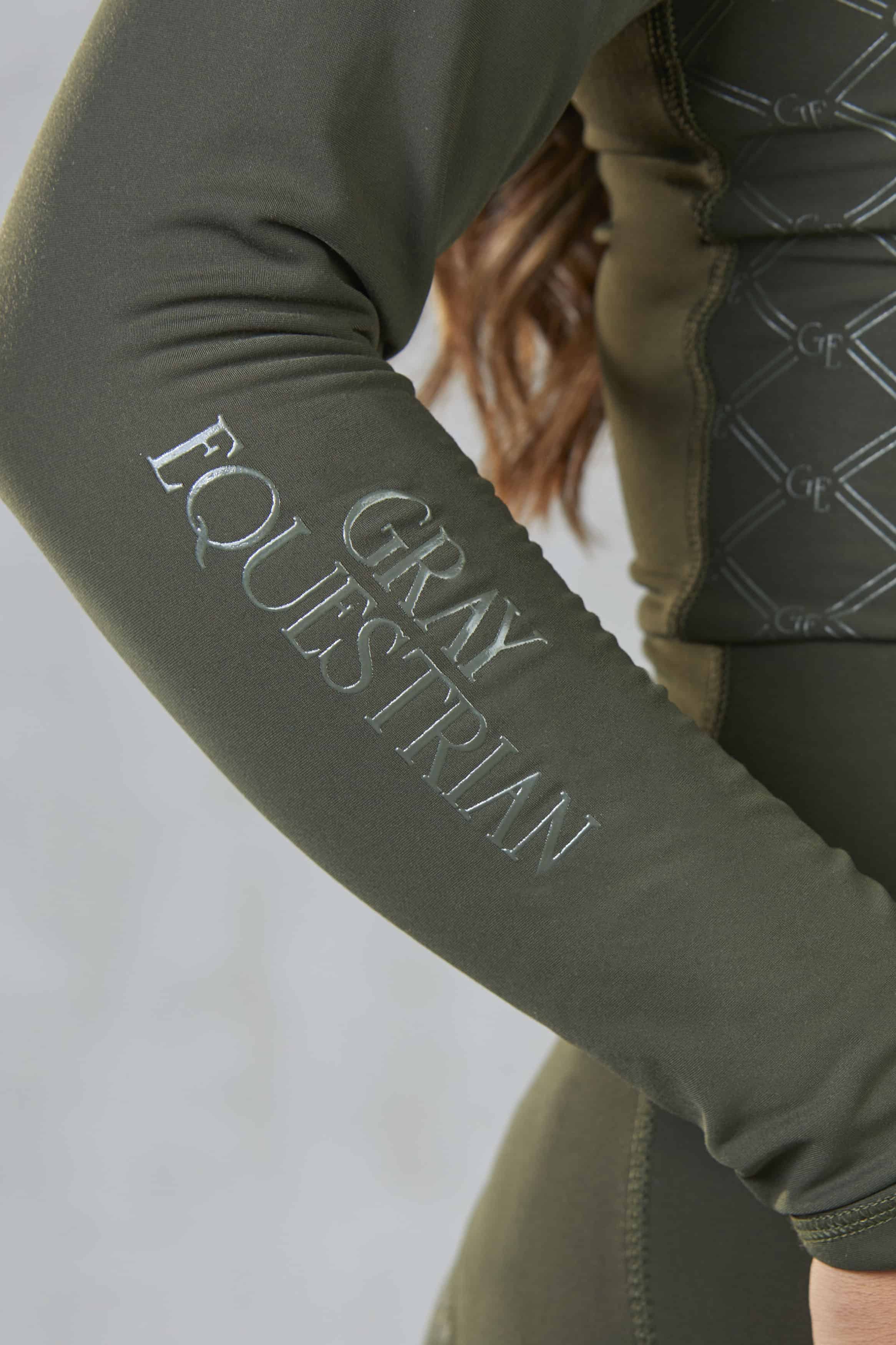 A close up of the subtle Gray Equestrian branding on the sleeve of our base layer.