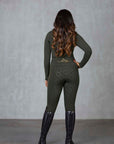 A brunette model wearing our fleece lined long sleeve khaki base layer and matching khaki riding leggings.
