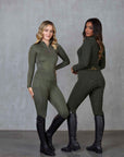 Two models standing next to each other. The one on the left is wearing a fleece lined long sleeve green base layer and matching riding leggings. The model on the left is wearing our fleece lined khaki base layer and leggings.