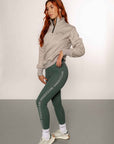 A model wearing our 1/4 zip grey jumper and green riding leggings.
