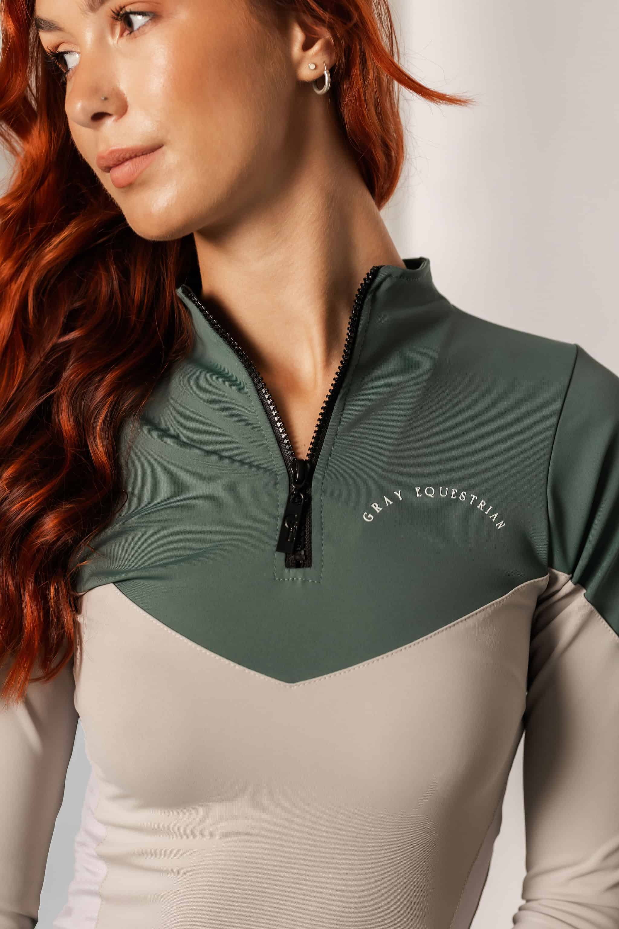 A vide of the front of our long sleeved 1/4 zip grey and green two toned base layer.