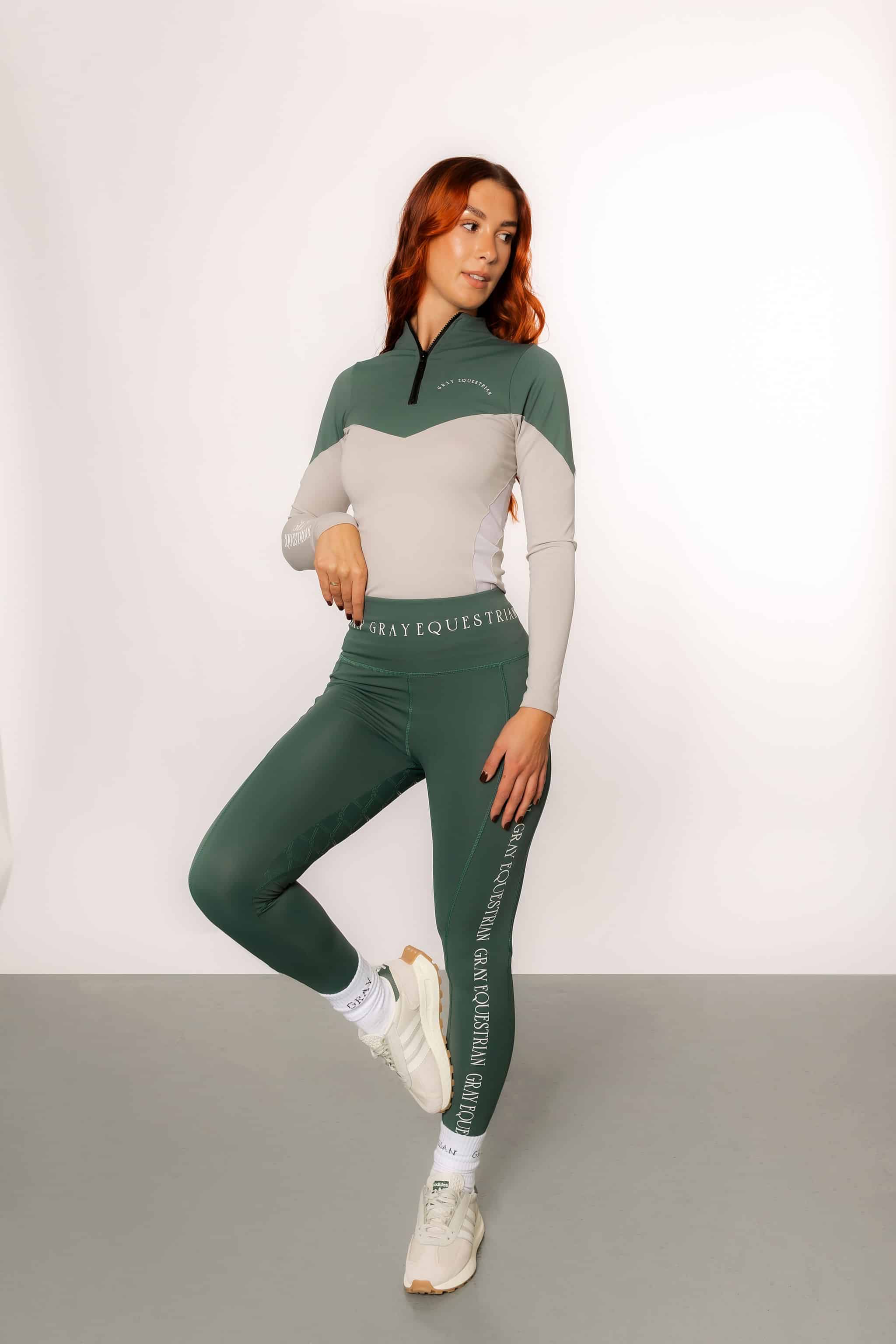 A model wearing our green and grey two toned base layer and matching green riding leggings.