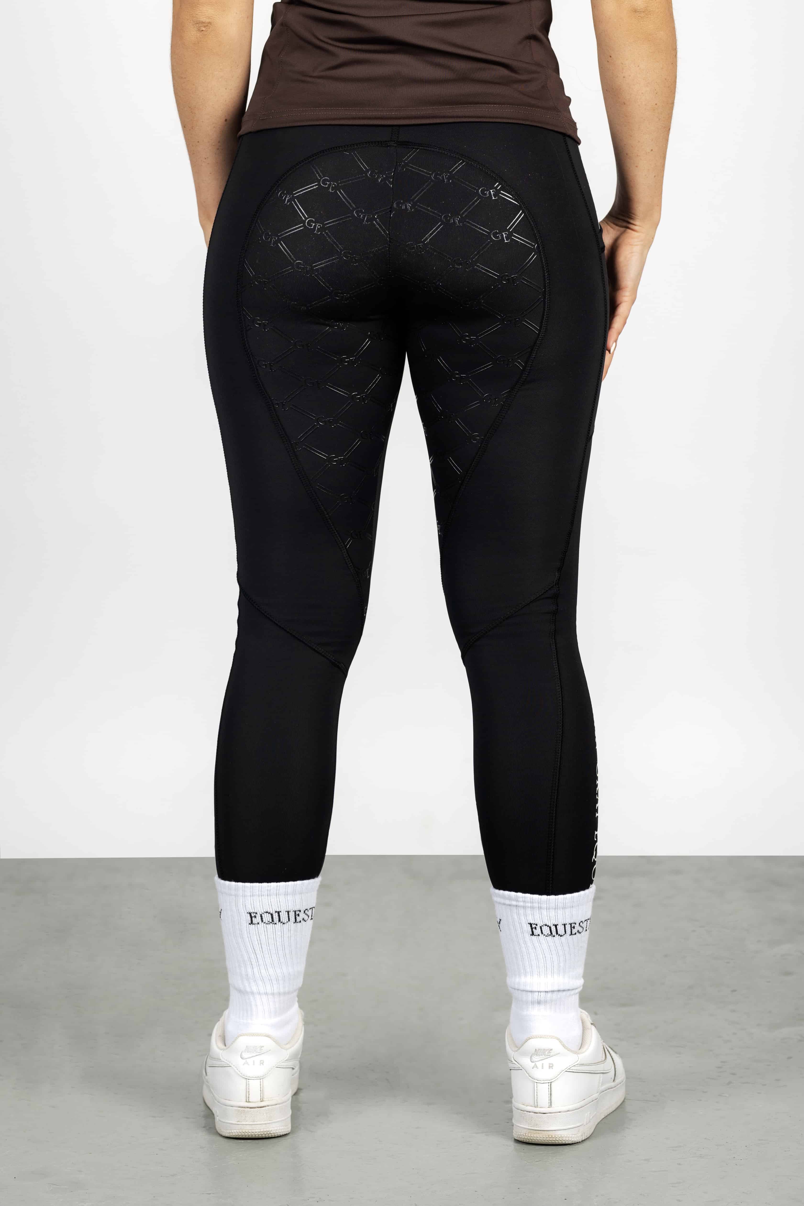 A view of the back of our black renew leggings with full non slip seat.