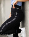 A close up of our black renew leggings with white Grey Equestrian branding down the side and waistband.
