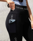 A close up of our black renew riding leggings with white Grey Equestrian branding down the side and on the waist band.
